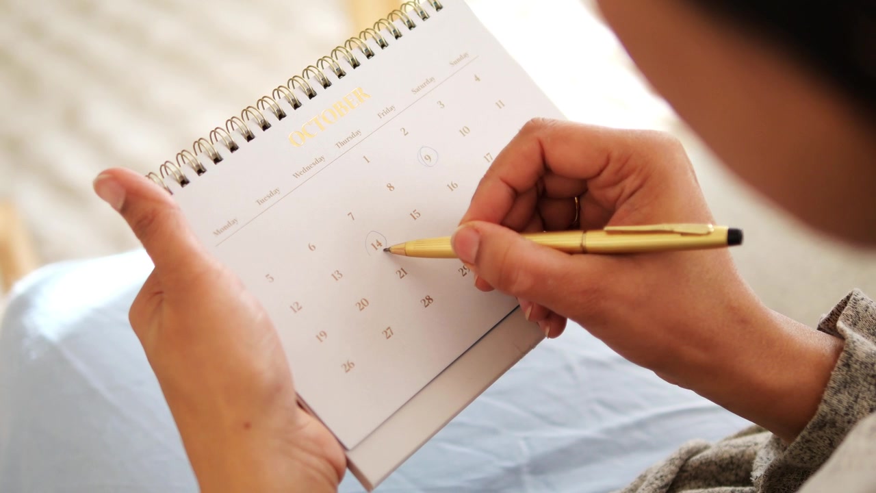 Person Marking Dates on an October Calendar
