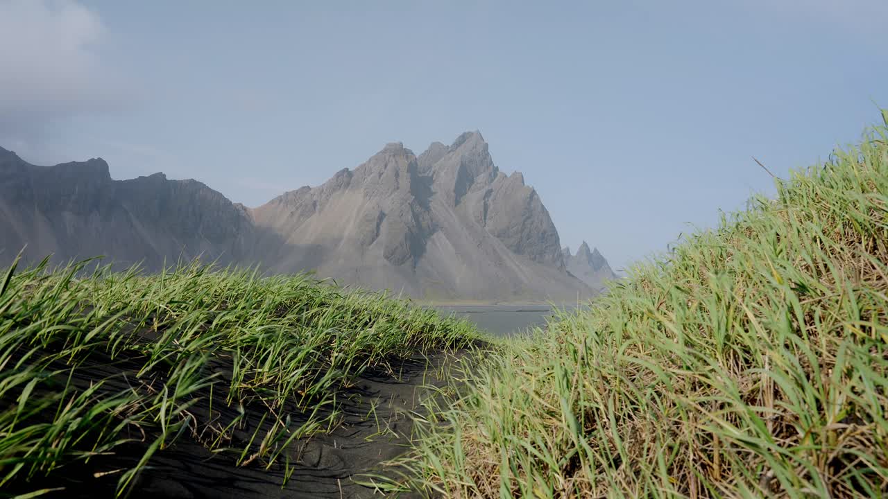 el impresionante monte vestrahorn costero islandés enmarcado por la hierba azotada por el viento, una serena mezcla de belleza accidentada y tranquilidad