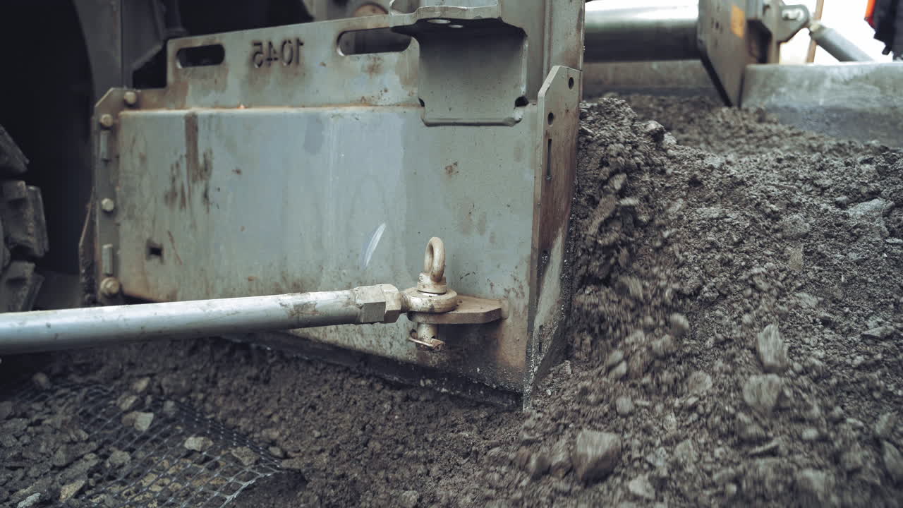 Construction site roadwork. Industrial pavement truck laying fresh asphalt on construction site