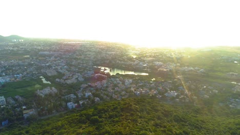 Drone-shot-moving-backwards-and-panning-with-a-mountain-and-sunset-with-shifting-solar-flare