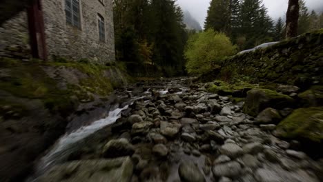 FPV-Drohnenansicht-Eines-Wasserstroms,-Der-Durch-Die-Stadt-Mello-In-Norditalien-Fließt