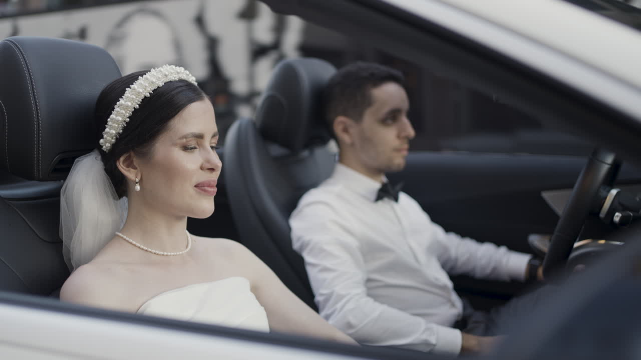 Bride and Groom in a White Convertible Car