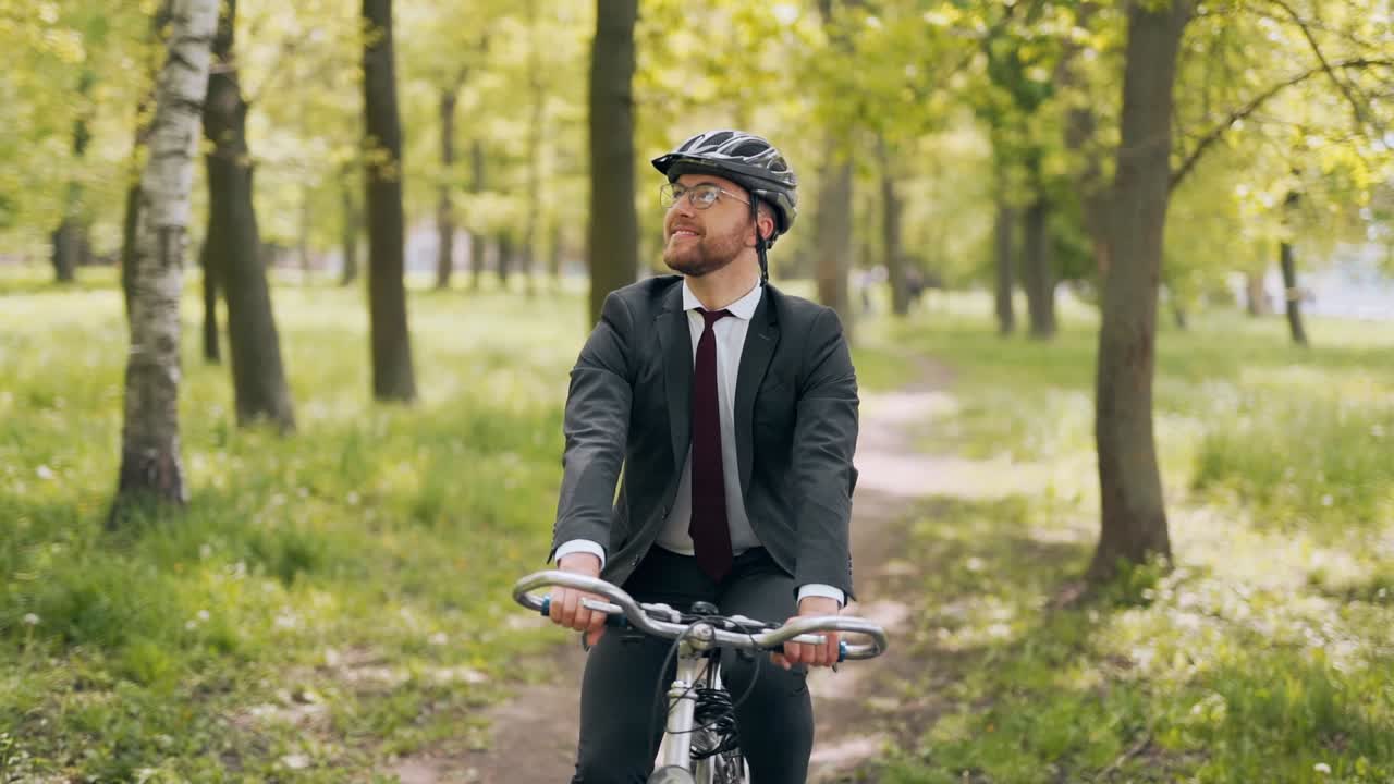 공원에서 자전거를 타고 비즈니스 정장을 입은 행복한 남자