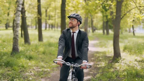 gelukkige man in een pak op een fietstocht in het park