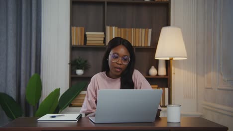 mujer trabajando en una computadora portátil en casa