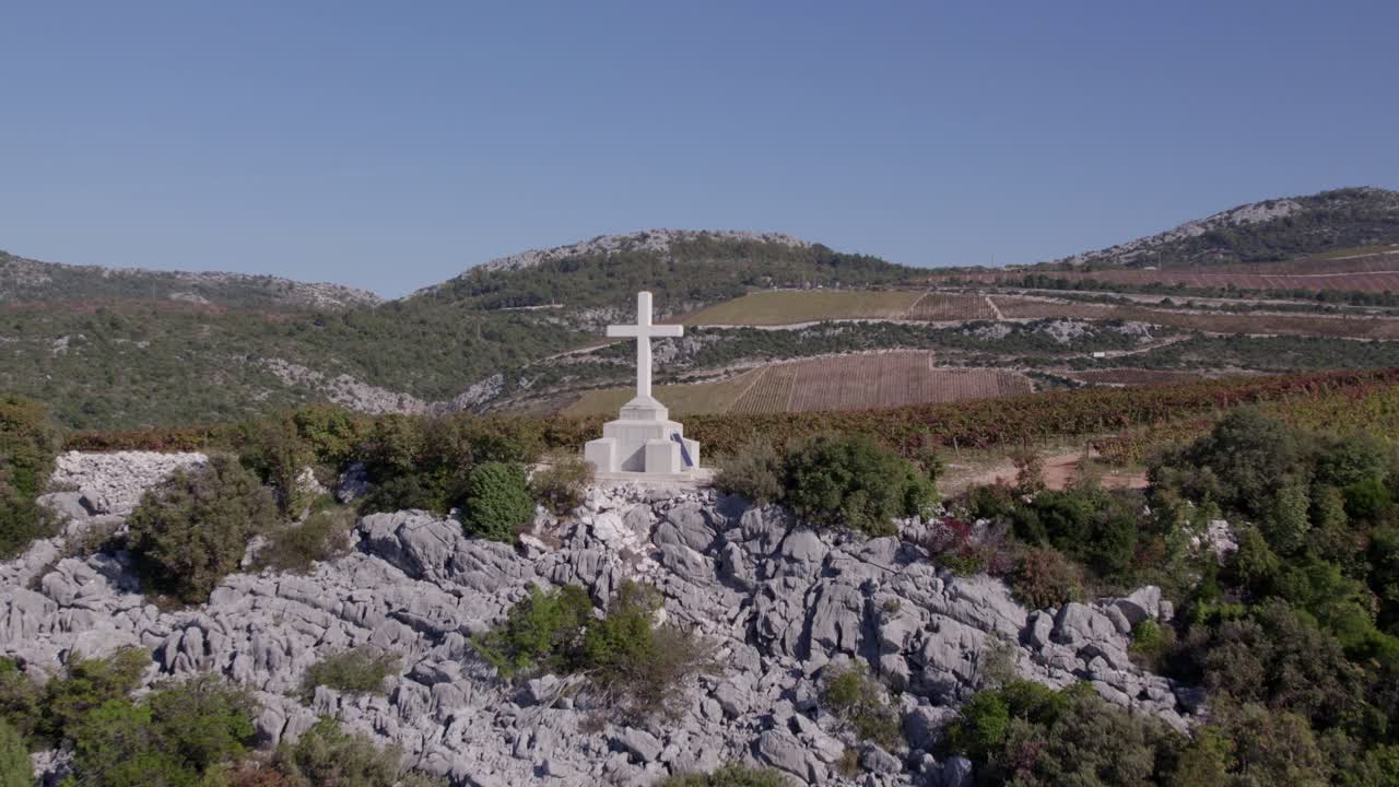 Vista a volo d'uccello di un vigneto e una croce consumata tra le colline, Slivno, Croazia
