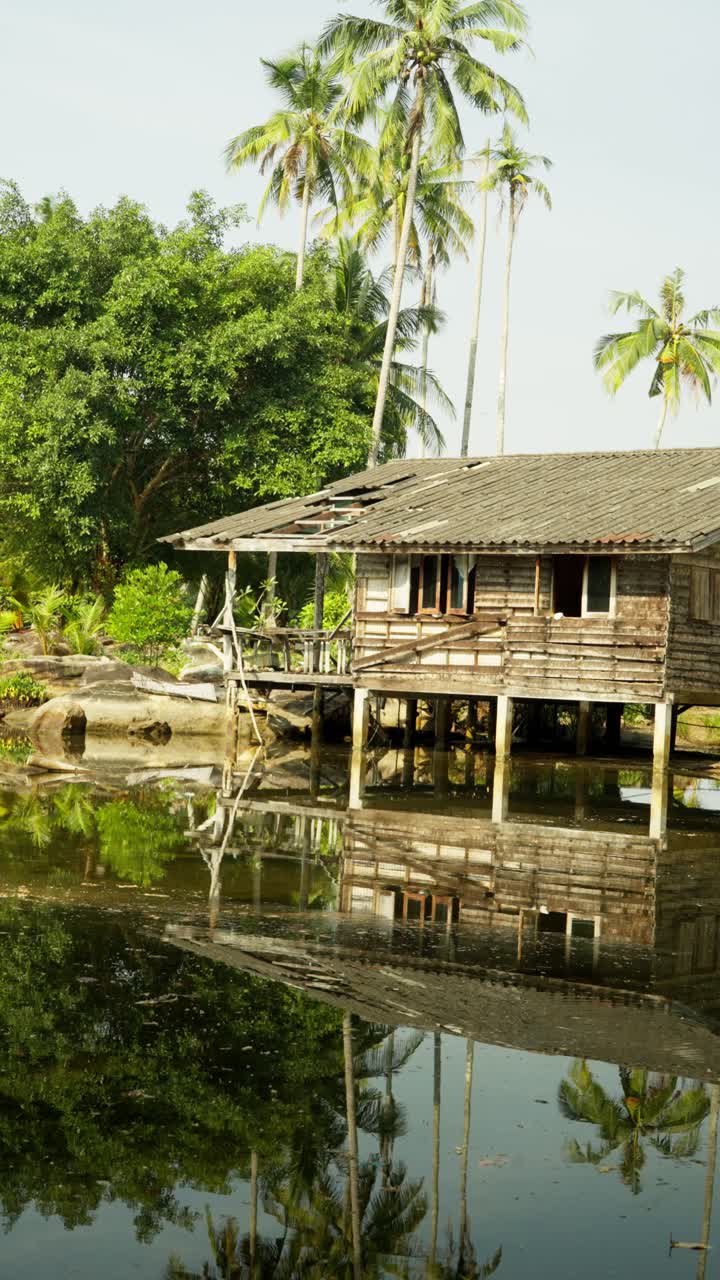 Vertical, shot of broken down shack and picturesque reflections during the day in Thailand, outdoor