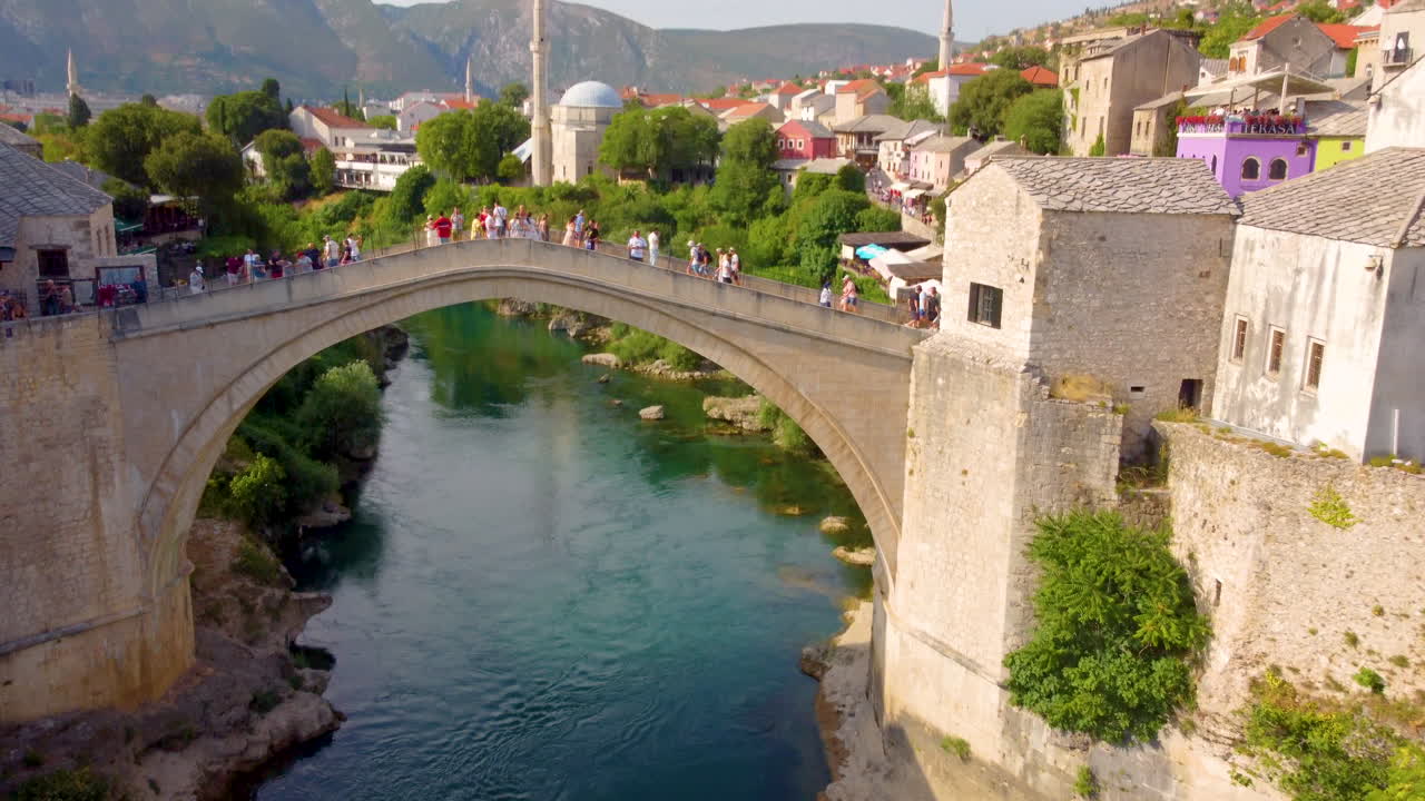 mostar stari most - antiguo puente arqueado sobre el río neretva popular para los turistas en el fondo en mostar, bosnia y herzegovina