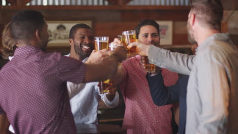 grupo de amigos masculinos en la noche de despedida de soltero en un bar haciendo un brindis juntos