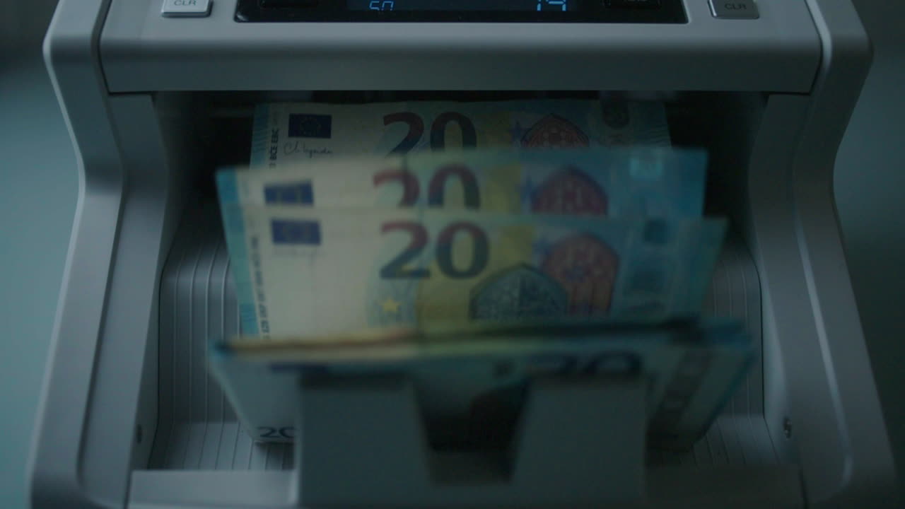 Euro 20 banknotes being counted by a machine