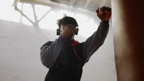 low angle footage young male boxer practicing shadowboxing in headphones