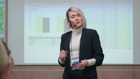 Entrenadora-Emocional-En-Conferencia-De-Negocios-Retrato-De-Mujer-Adulta-Contra-Gráficos-De-Educación-Profesional