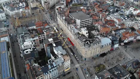 aerial forward flight over brussels city on cloudy day while bus is passing, belgium