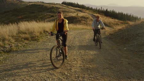 Couple-cycling-on-sport-bikes-in-mountains.-Man-and-woman-riding-mountain-bikes