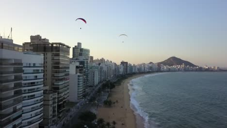 paragliding over a coastal city beach