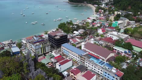 aerial view of tour boats anchored at the bay against the beach of el nido town seen from canopy walk, also called taraw cliff, philippines