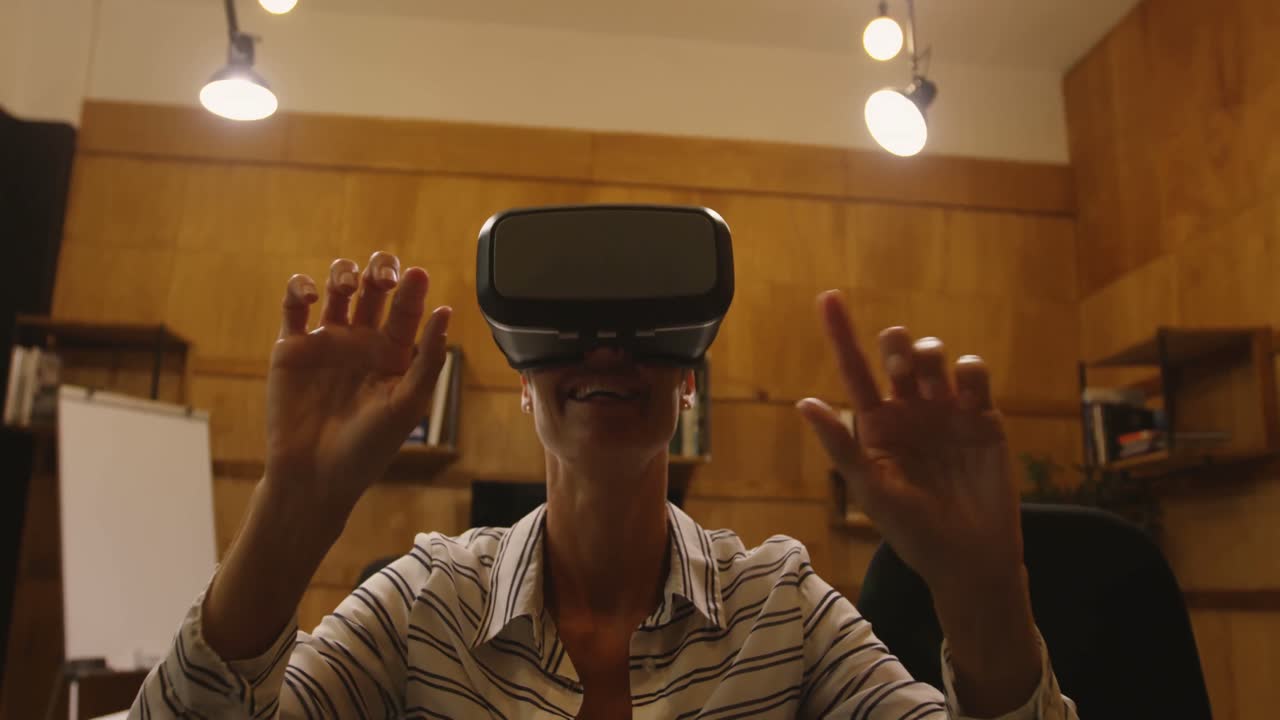 Business woman gesturing while using Virtual reality headset at office 4k