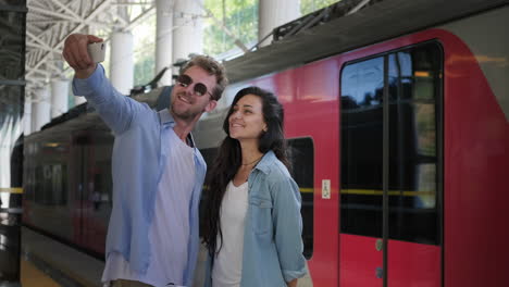 una pareja tomando una selfie en una estación de tren
