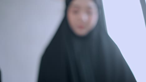 young muslim woman reading quran during praying