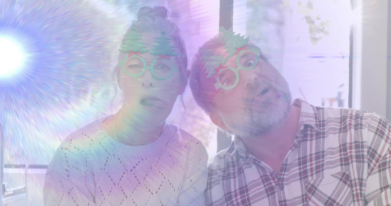 Senior couple laughing noticing swirling rainbow light and sharing surprise reactions in holiday ad