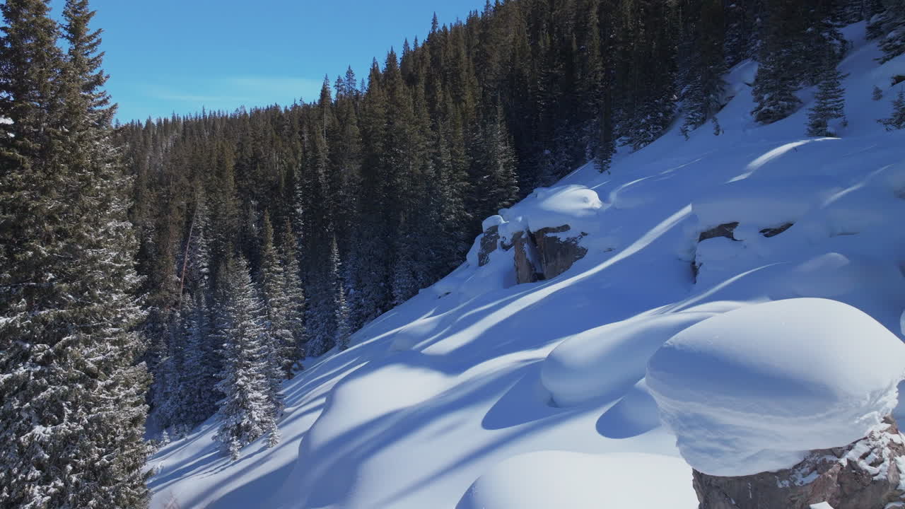 Dreamy backcountry winter Cup Cakes Pillows Vail Pass Colorado Aerial Drone sunny blue sky fresh deep powder snow snowboard ski snowmobile paradise rock boulder drops cinematic forward slowly motion