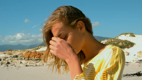 vista lateral de una joven mujer caucásica relajándose en la playa 4k