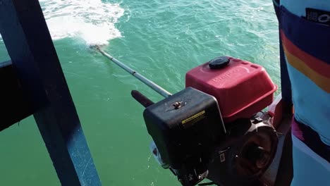 slow motion shot of a small tourist transport boat motor spinning in a turquoise river tilting up to reveal the tropical restinga beach sailing towards barra de cunhaú in rio grande do norte, brazil