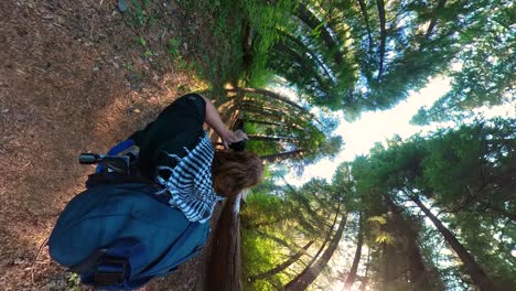 a backpacker uses his camera to get pictures of a deer in the oregon forest