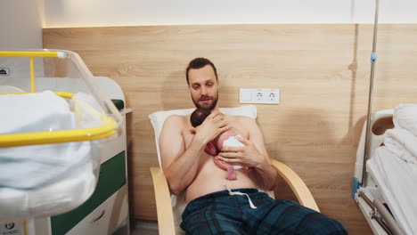 father holding newborn baby in hospital