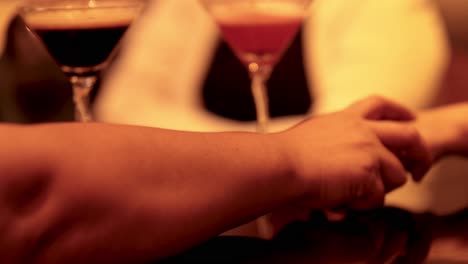 dos manos alcanzando a través de una mesa de bar