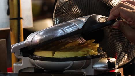 preparing and cooking waffles in a kitchen