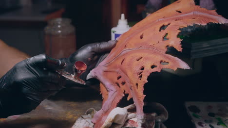 el hombre del taller de pintura pinta un modelo impreso en 3d con un aerógrafo de cerca