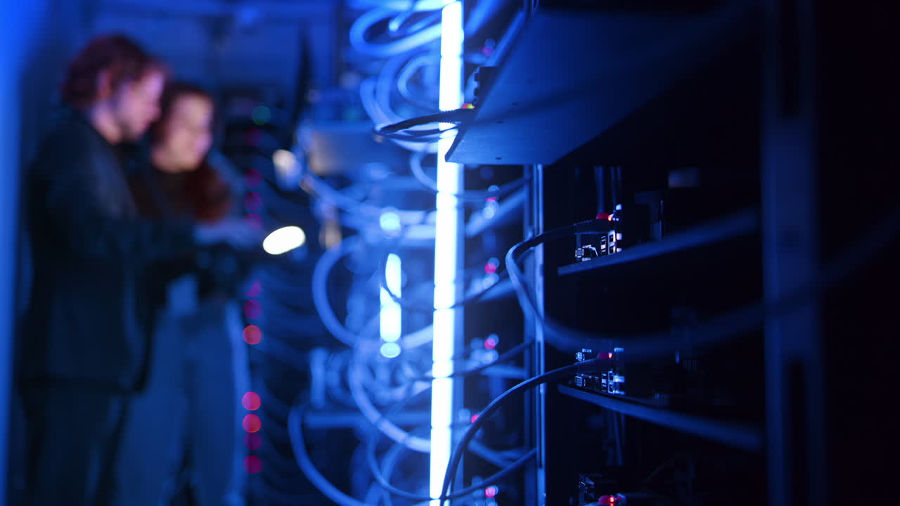 A man and a woman programming in a server room