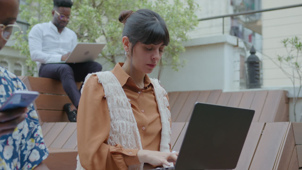 joven mujer de negocios usando una computadora portátil en un espacio de coworking al aire libre