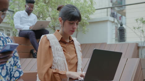 young business lady using laptop at outdoor coworking space