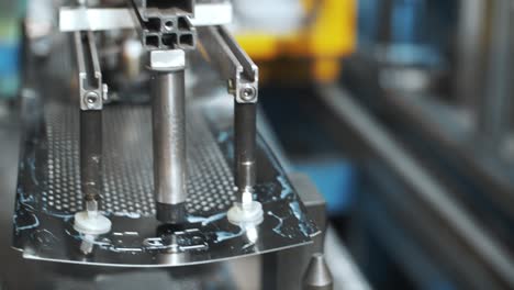 Robotic-manipulator-moving-perforated-metal-sheets-for-washing-drum-at-factory