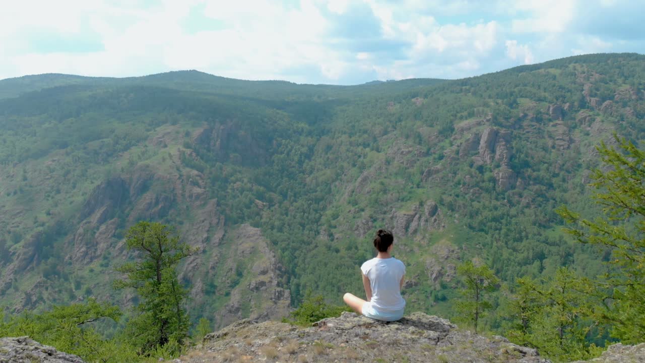 드론이 절벽 위에 있는 소녀와 함께 인상적인 산을 날아다니며, 어지러움 효과