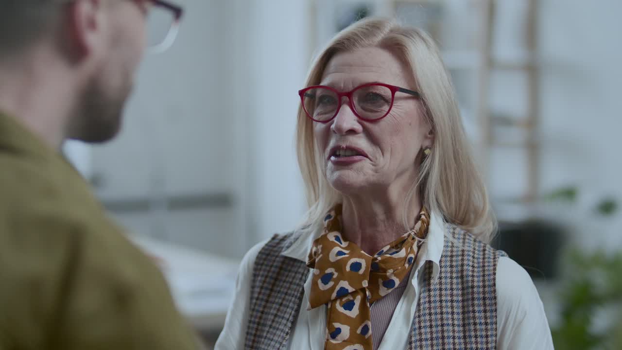 Beautiful Senior Businesswoman Speaking with Colleague in Office