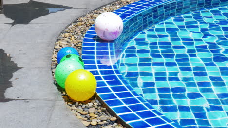 colorful beach ball on edge and floating in pool