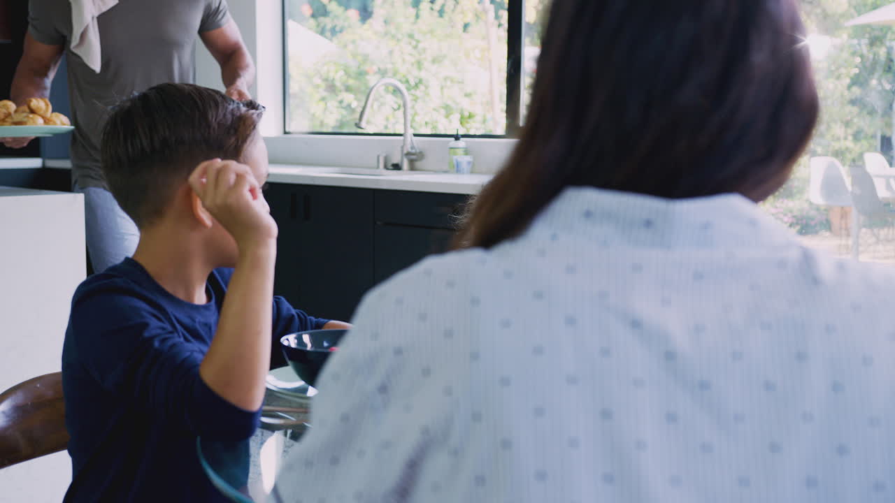 테이블 주위에 앉아 함께 아침 식사를 하는 히스패닉 가족