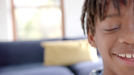half portrait of happy african american boy at home with copy space, slow motion