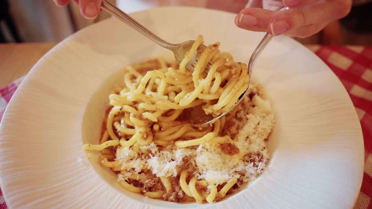 Primo piano di un piatto di pasta cremosa servito su un piatto, con una texture ricca e tonalità calde