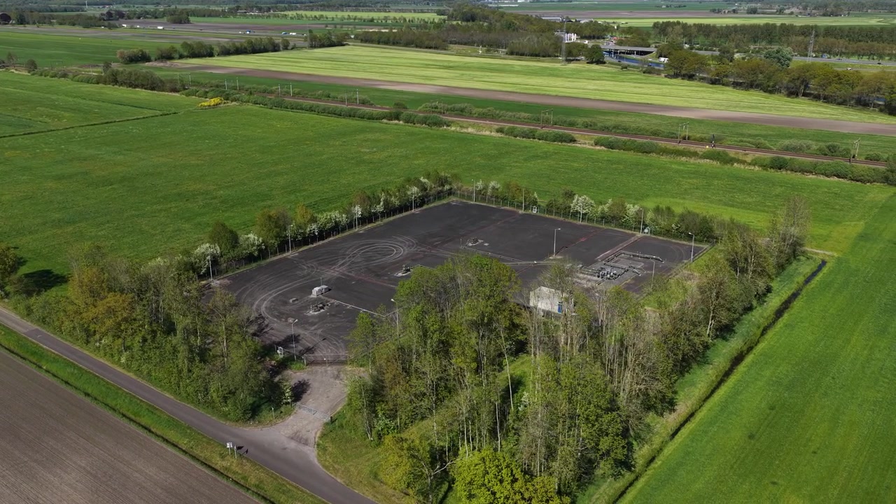 Aerial drone view of underground gas extraction and transport installation, showing pipelines, energy infrastructure, and industrial facilities.