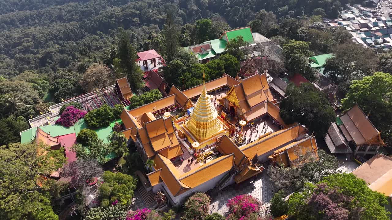 Stunning birds eye reveal to pagoda and tourist visiting Doi Suthep Buddhist Temple in Chiang Mai.