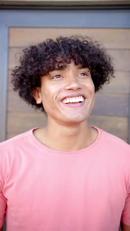 vertical video: a young biracial man is beaming with joy