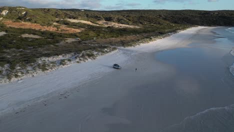 Isolated-person-with-off-road-vehicle-4x4-on-beach-after-bath-in-ocean-waters,-Bremer-Bay-in-western-Australia