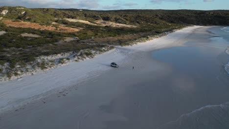 persona aislada con vehículo todo terreno 4x4 en la playa después de bañarse en las aguas del océano, bremer bay en australia occidental