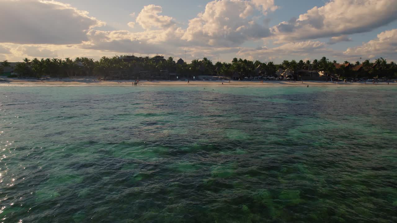 drone volando sobre el hermoso mar verde hasta la playa de akiin con los árboles en el fondo