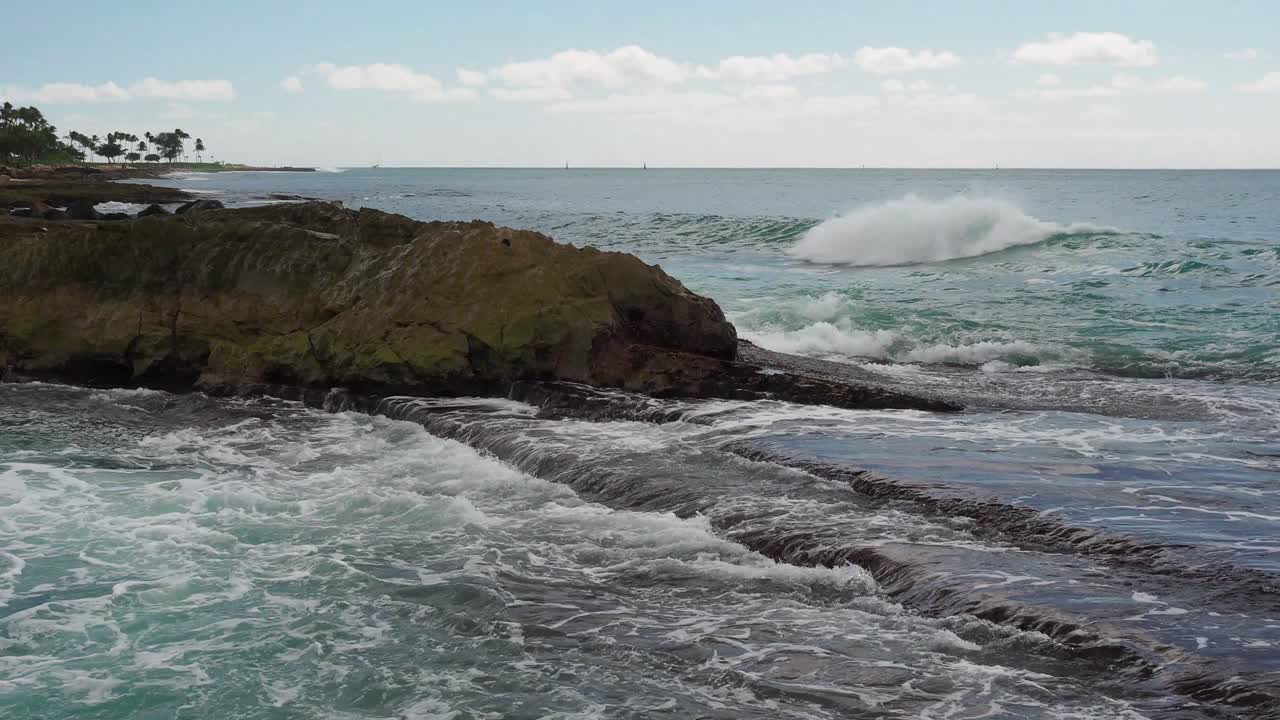olas rompiendo sobre las rocas volcánicas de oahu