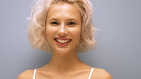 mujer joven sonriente con cabello corto rubio